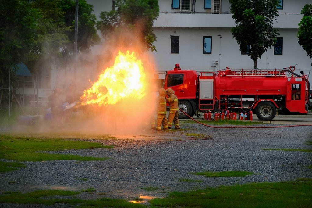 Instructor showing how to use a fire extinguisher on a training fire